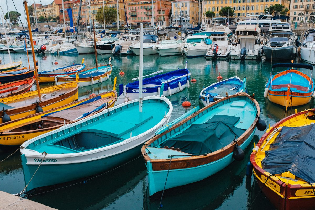 Traditional colourful fishing boats moored in Port Lympia in Nice in fine weather