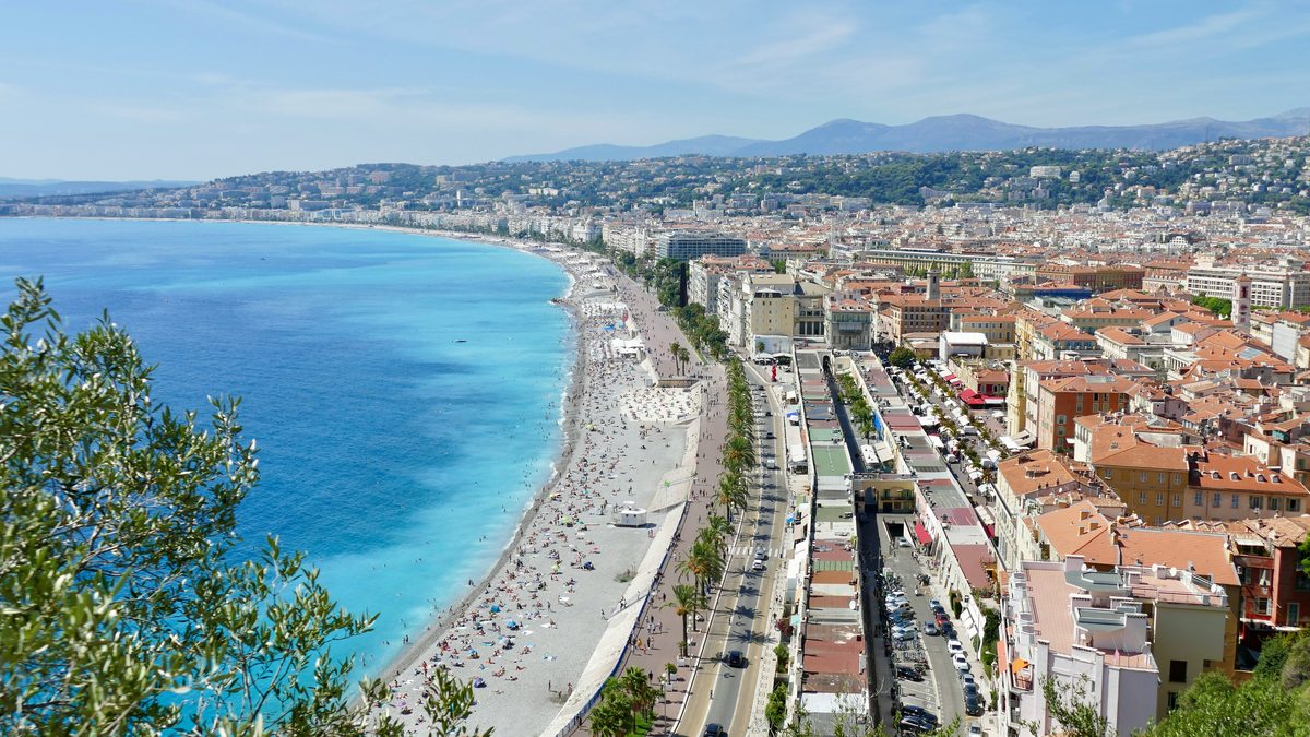 Panoramic view from Colline du Château over the Promenade des Anglais and Nice's pebble beaches in summer, turquoise Mediterranean sea